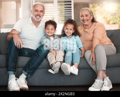 Guarda chi è venuto a visitare. Colpo di due fratelli piccoli che trascorrono il tempo con i loro nonni a casa. Foto Stock