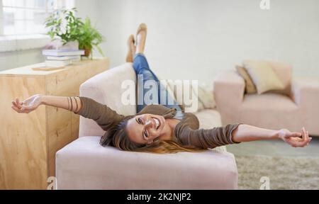 Ora locale = tempo libero. Ritratto corto di una donna attraente rilassante sul divano a casa. Foto Stock