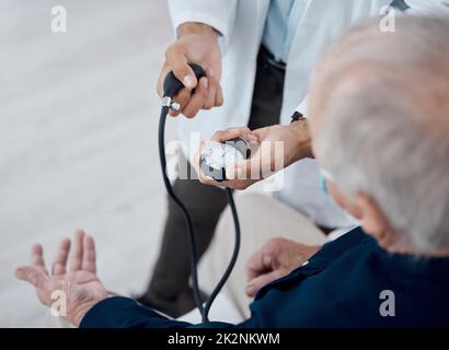 I controlli regolari della pressione sanguigna sono importanti. Shot di un medico irriconoscibile che controlla la pressione sanguigna di un paziente in un ufficio. Foto Stock