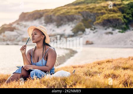 Il problema sa nuotare. Scatto di una giovane donna che scrive nel suo diario alla spiaggia. Foto Stock