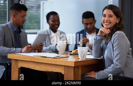 Impegno individuale per uno sforzo di gruppo. Foto di un gruppo di colleghi che hanno una riunione e la colazione in un ufficio moderno. Foto Stock