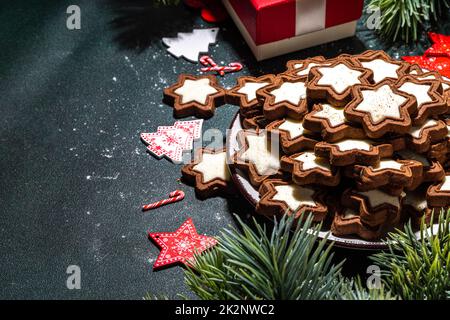 Biscotti glassati con zucchero a stella natalizia, tradizionale cioccolato fondente e bianco di Natale biscotti di pan di zenzero con decorazione di festa, regali, reggiseno di albero di Natale Foto Stock