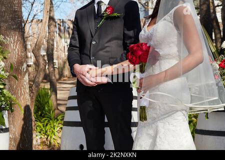 Il grande giorno è finalmente arrivato. Scatto corto di una sposa e sposo alla loro cerimonia nuziale esterna. Foto Stock