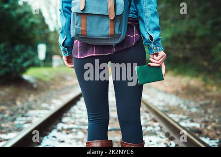 Il libro che mi porterà posti. Ripresa da una donna irriconoscibile che cammina sui binari del treno all'aperto. Foto Stock