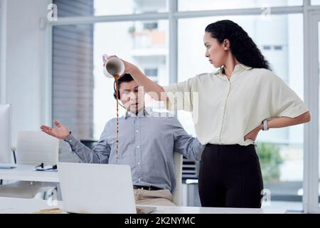 Questo è il ritorno sull'investimento per quello che hai fatto. Shot di una donna d'affari che versa una tazza di caffè sulla scrivania di un collega in un call center. Foto Stock