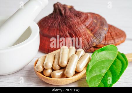 Lingzhi o Reishi funghi con capsule, alimenti biologici naturali sani. Foto Stock
