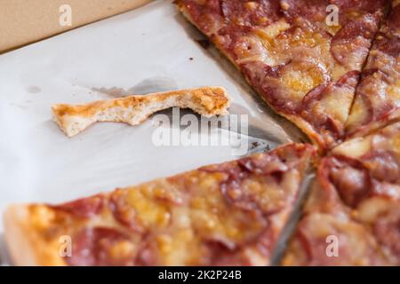 Primo piano di avanzi di deliziosa pizza fatta in casa. Consegna pizza al peperoni Foto Stock