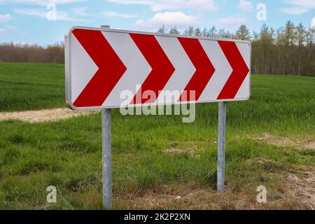 Un grande segnale di avvertimento per una curva molto affilata su una strada di campagna tedesca Foto Stock