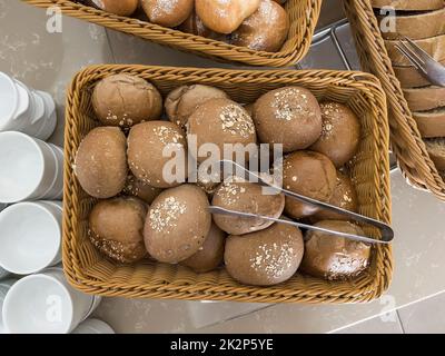 Deliziosi panini in un cestino di vimini sul tavolo. Foto Stock
