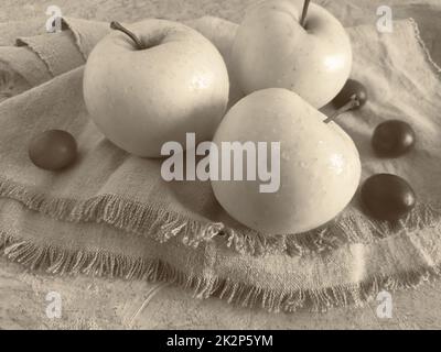 Mele e prugne sulla tavola su un tovagliolo. Foto Stock