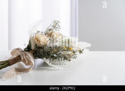 Bouquet di fiori secchi posto su un tavolo bianco. Foto Stock