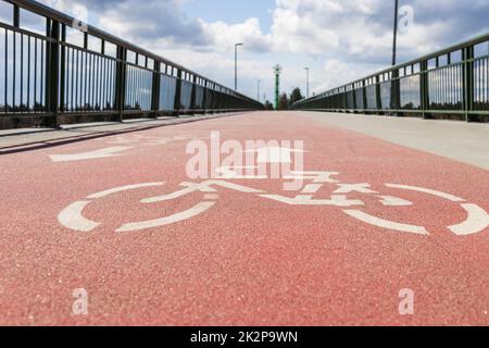 Il cartello della bicicletta, simbolo della corsia della bicicletta, indica la strada per le biciclette sul ponte pedonale Foto Stock