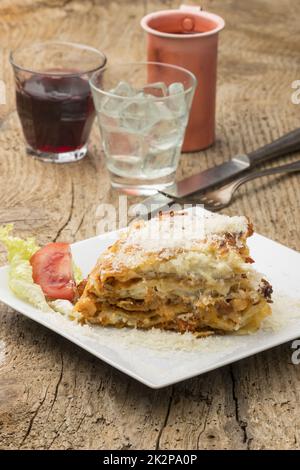 porzione di lasagna su un piatto bianco Foto Stock