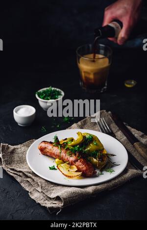 Salsiccia di maiale al forno con peperoni verdi, cipolla ed erbe Foto Stock