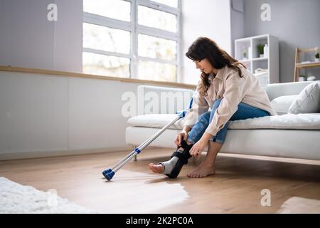 Donna con lesioni alle gambe con stampelle Foto Stock