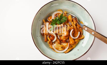 Funghi marinati a base di miele selvatico Armillaria mellea funghi con spezie e cipolle nel recipiente. Foto Stock