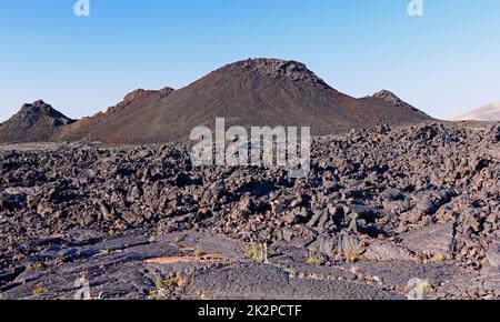 Flussi di lava e coni di Cinder in un paesaggio desolato Foto Stock