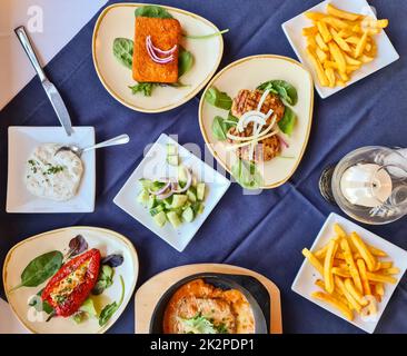 Molte ciotole con cibo su un tavolo - buffet greco in un ristorante. Foto Stock