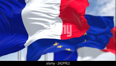 Particolare della bandiera nazionale francese che sventola al vento con la bandiera dell'Unione europea sfocata sullo sfondo in una giornata limpida. Foto Stock