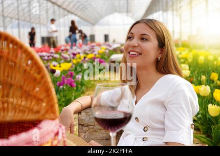 Giovane donna rilassata tra i fiori in pic-nic in primavera. Messa a fuoco selettiva. Foto Stock