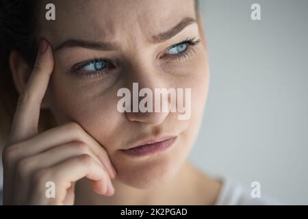 Ansiosa, preoccupata, stressata giovane donna che guarda penosa, ponderante, profonda nei pensieri. Foto Stock