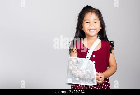 Piccola ragazza cute capretto 3-4 anni osso della mano rotto da incidente con stecca del braccio in studio sparato isolato Foto Stock