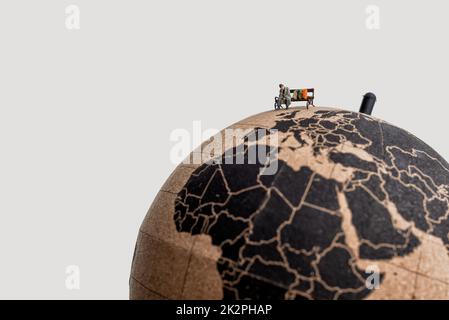 Povero senzatetto seduto in cima al globo. Concetto di povertà globale Foto Stock