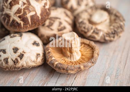 Funghi shiitake secchi su sfondo di legno. Cibo sano. Foto Stock