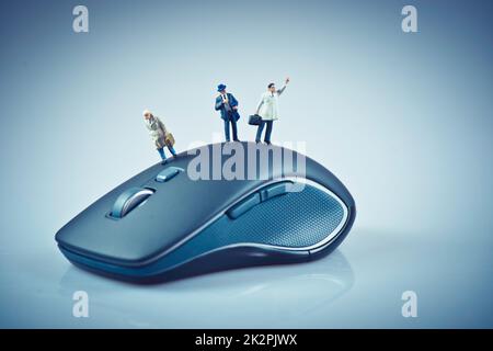 Persone in miniatura sopra il mouse del computer. Concetto aziendale Foto Stock