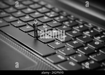 Poliziotti in miniatura ispezione portatile. La pirateria web internet e concetto di hacking Foto Stock
