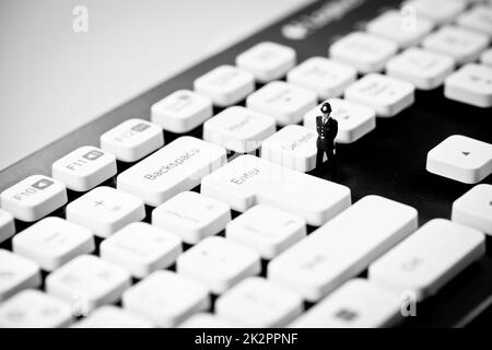 Poliziotto in miniatura sulla tastiera del computer. Pirateria Internet e criminalità cpncept Foto Stock