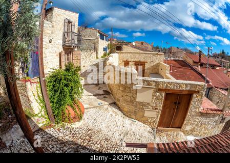 Strada vuota sotto il cielo azzurro soleggiato al villaggio di Lofou. Limassol Distretto di Cipro Foto Stock