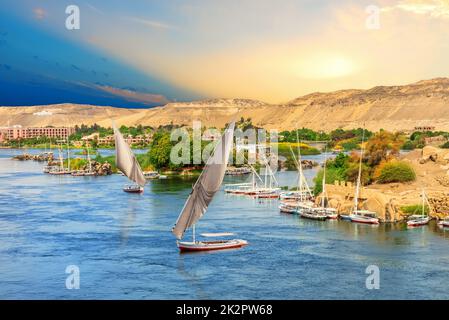 Barche a vela di fronte alle colline del Nilo ad Assuan, Egitto Foto Stock