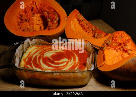 Cheesecake fatta in casa con torta di zucca e un pezzo di zucca. Dessert all'arancia. VISTA LATERALE Foto Stock