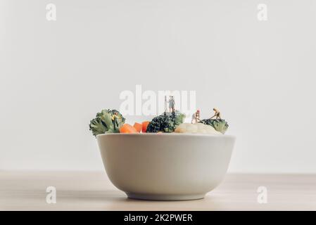 Recipiente pieno di insalata fresca verde raccolte dagli agricoltori in miniatura Foto Stock