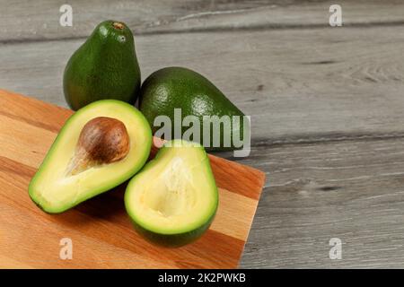 Avocado fresco e maturo accanto all'avocado marcio tagliato in metà con  seme visibile isolato su bianco Foto stock - Alamy