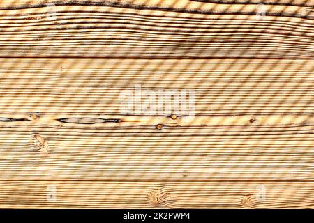Vista dall'alto - scrivania realizzata con tavole di legno illuminate dal sole di mattina, sfumature di lasciare strisce diagonali pattern. Abstract sfondo di legno. Foto Stock