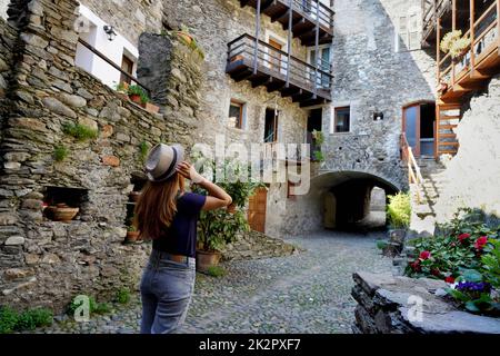 Bella giovane donna in visita a Sondrio pittoresca e accogliente cittadina alpina in Valtellina, Lombardia, Italia Foto Stock