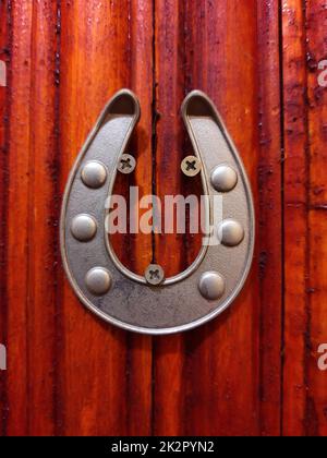 Ferro di cavallo su una porta di legno Foto Stock