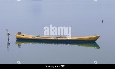 Vista ravvicinata su una bella barca a remi in legno ormeggiata sul lago Foto Stock