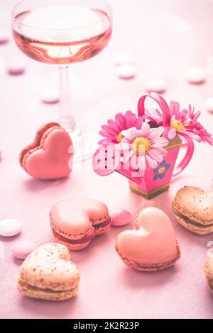 Happy Mothers Day - dolci macaron e bicchiere di spumante rosato con fiori in tonalità rosa Foto Stock