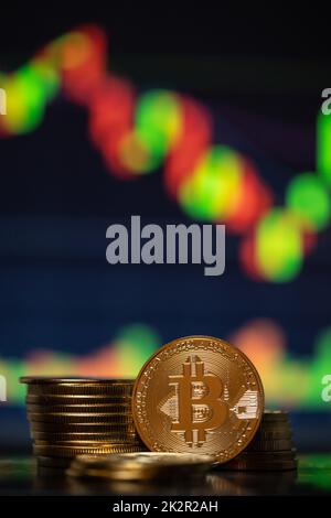 Bitcoins d'oro con grafico a candela e sfondo digitale Foto Stock