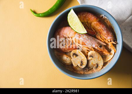 Tom Yum Goong Spicy Sour Soup sul tavolo alla moda vista dall'alto, cibo tailandese locale Foto Stock