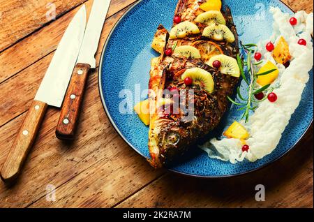 Carpa arrosto con frutta. Foto Stock