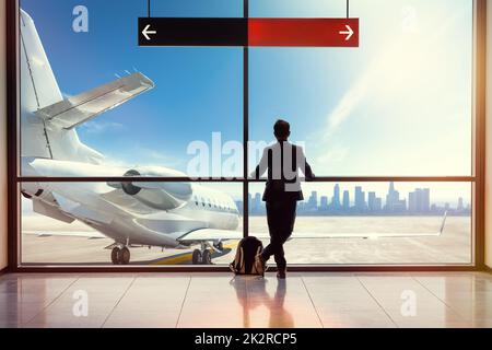 il passeggero dell'aeroporto sta guardando un aereo Foto Stock