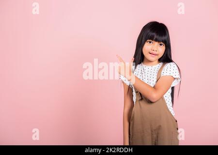 Bambino asiatico 10 anni punto con indice dito in alto Foto Stock