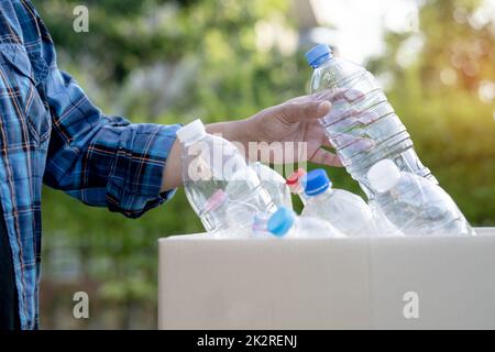 Donna asiatica volontario trasportare bottiglie di plastica di acqua in spazzatura scatola rifiuti in parco, riciclare ambiente ecologia concetto. Foto Stock