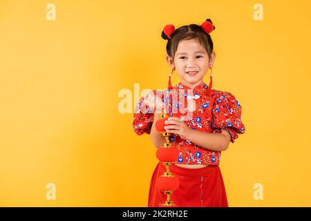 Felice ragazza cinese asiatica sorridere vestendo rosso cheongsam qipao tenendo lanterne di seta Foto Stock