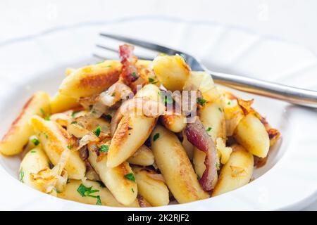 schupfnudeln con pancetta, cipolla e prezzemolo Foto Stock