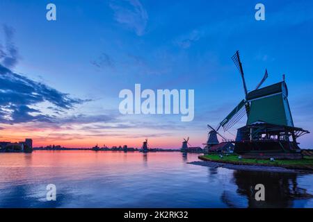 Mulini a vento nel famoso sito turistico Zaanse Schans in Olanda con cielo drammatico. Zaandam, Paesi Bassi Foto Stock